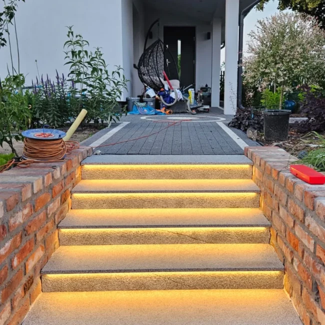 Nowoczesne schody zewnętrzne z gotowych stopni i podstopnic z szarego granitu G603, podkreślające elegancję i trwałość materiału.