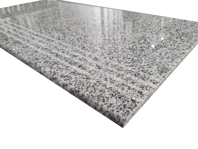 Zdjęcie przedstawia powierzchnię granitu G603 polerowanego z trzema równoległymi ryflami. Płytka o wymiarach 30,5x61x1 cm łączy piękno z funkcjonalnością.